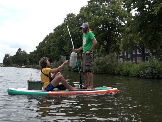 Afval in de grachten opruimen vanaf een sup