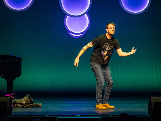 Henry van Loon op het podium met jongeren met autisme