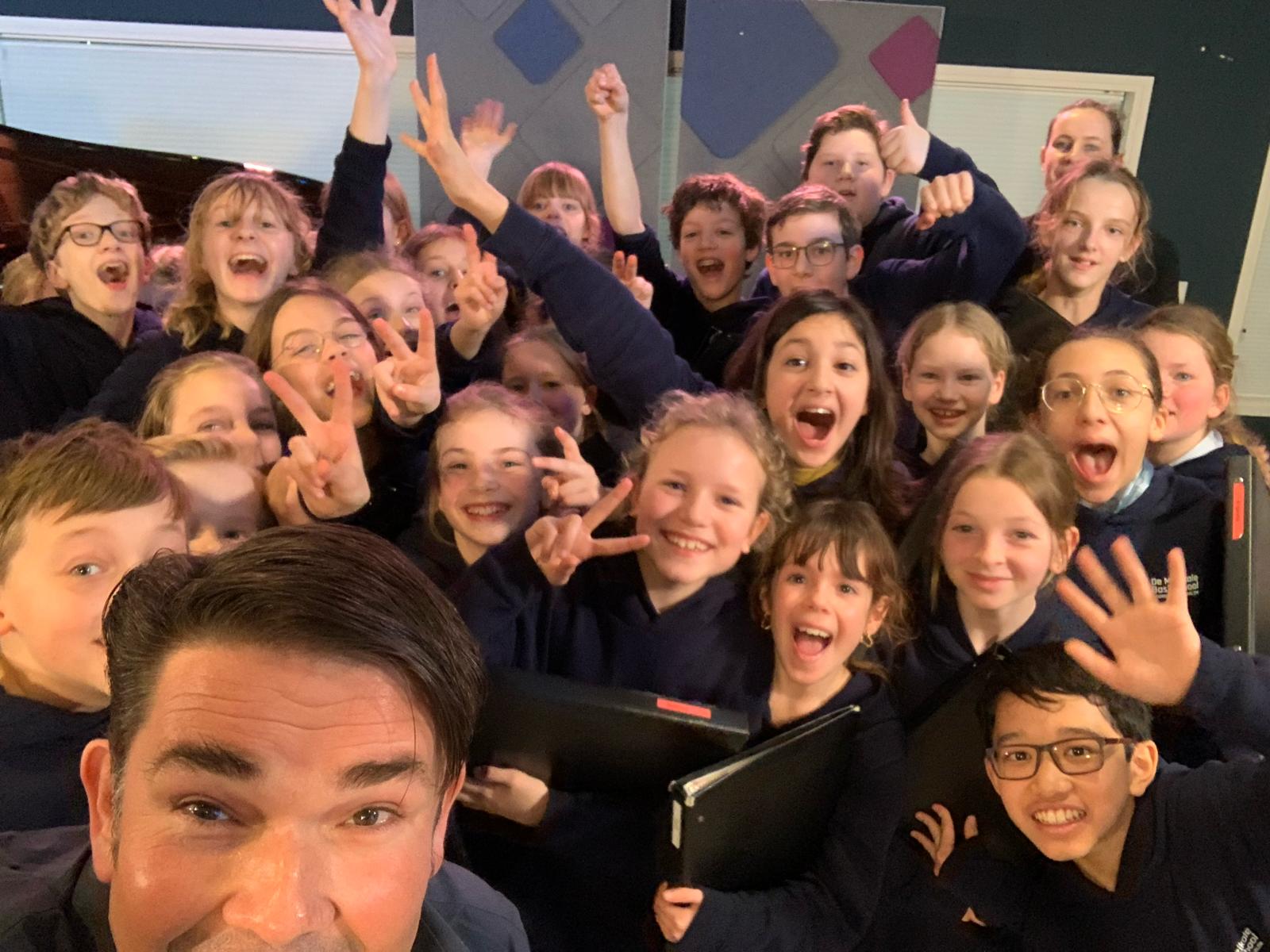 Ab Nieuwdorp op de foto met de kinderen/ leerlingen van de muzikale basisschool Koorschool Haarlem