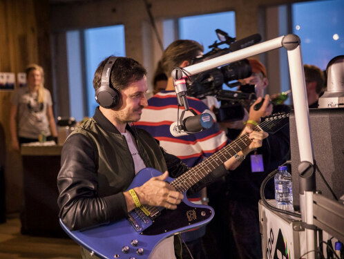 Frank plukt een Gibson van de muur zodat Burak Yeter een stukje kan spelen