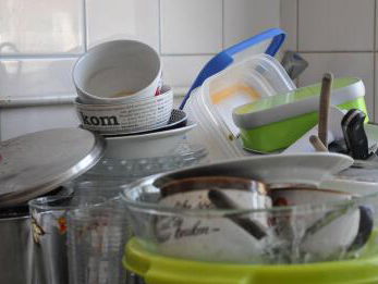 Medewerker van de Dag Yordi staat de pannen te boenen