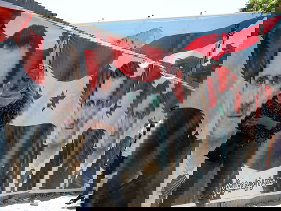 In een hokje tussen het puin stemmen mensen voor Assad