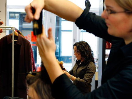 De kapper zit met haar handen in haar haar