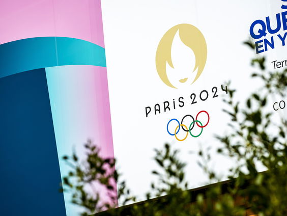 Olympische sporters lopen in Amsterdams merk DenHAM