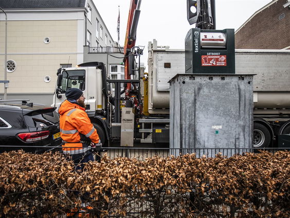 Vuilnisman redt hondje uit het vuilnis en houdt hem